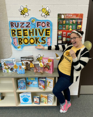 Mrs. Carter, dressed as a bee, presenting beehive book awards books.