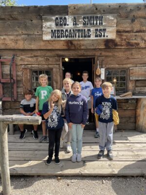 Children posed in front of pioneer mercantile store.