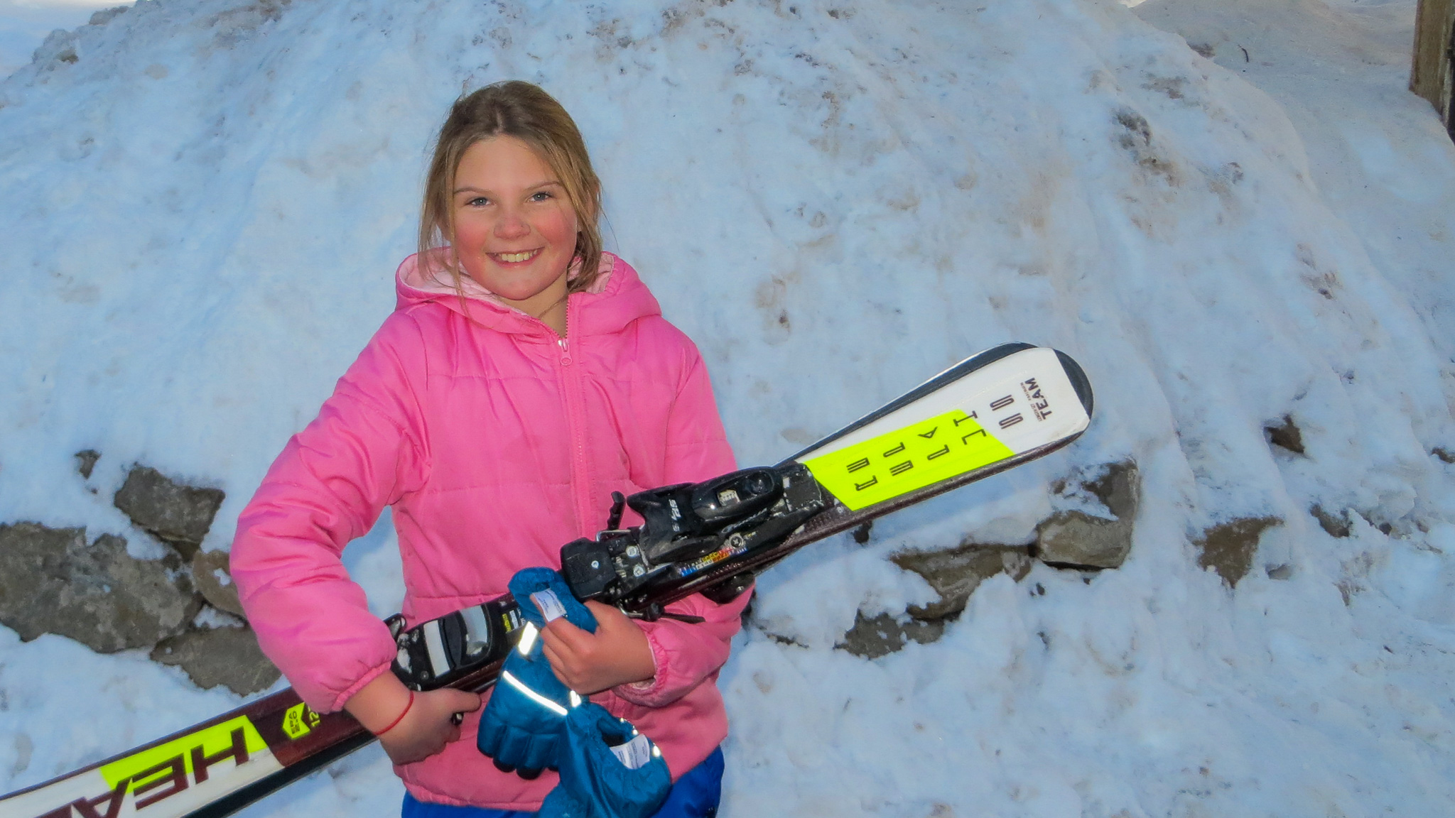 Student carrying ski/snowboarding equipment.