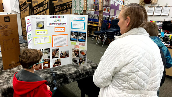 Child and woman reading a STEM display.