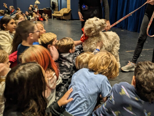 Students petting the dog from the play Annie.