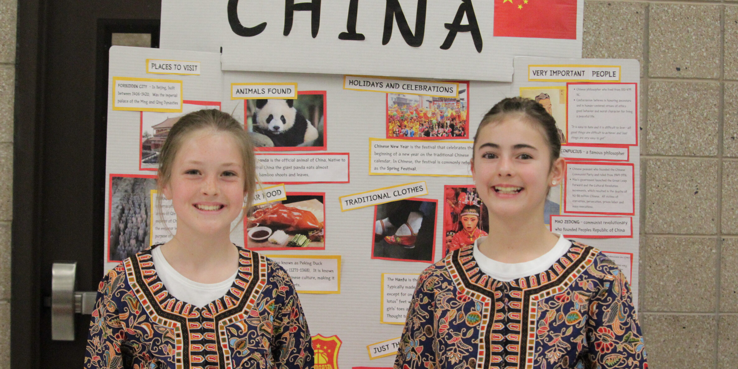 Two girls presenting China display.