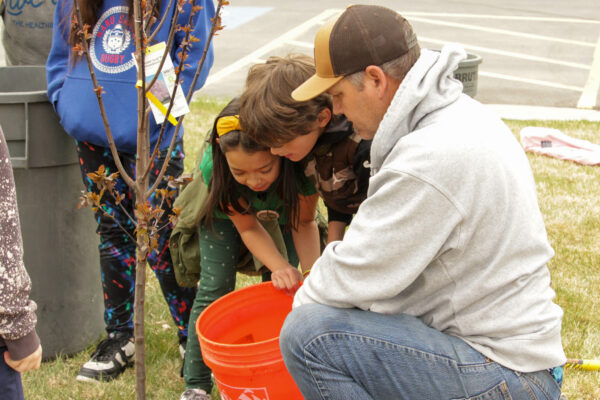 Students pouring water from a bucket.