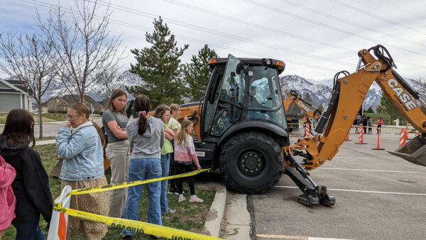 Students waiting in line to try their hand at backhoe.