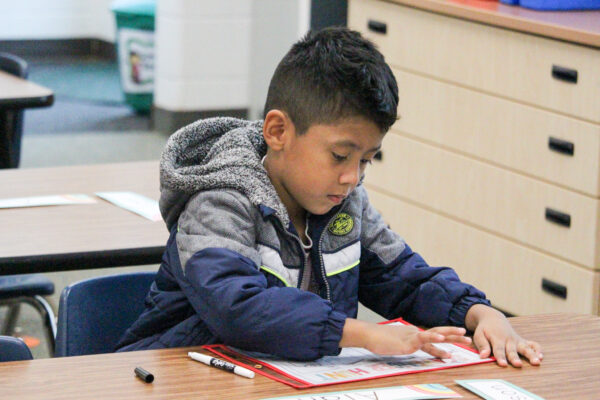 Young boy working at a desk.