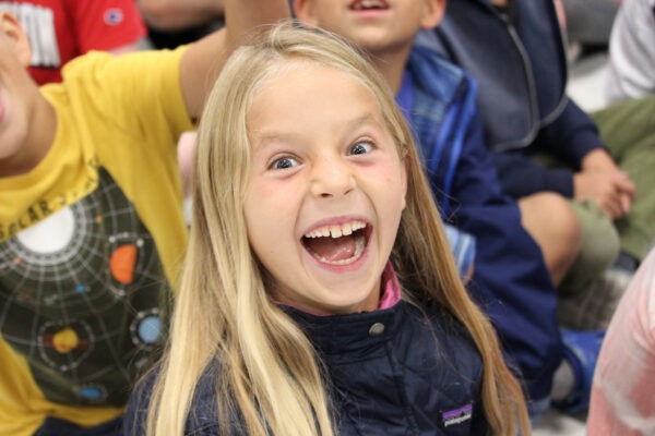 Student with huge smile shows her excitement.