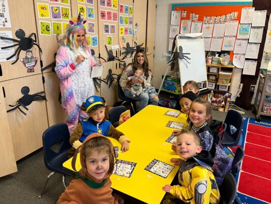 Mothers leading students in a Halloween game.