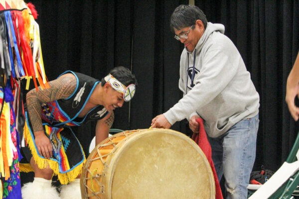 Two man packing up their traditional drum.