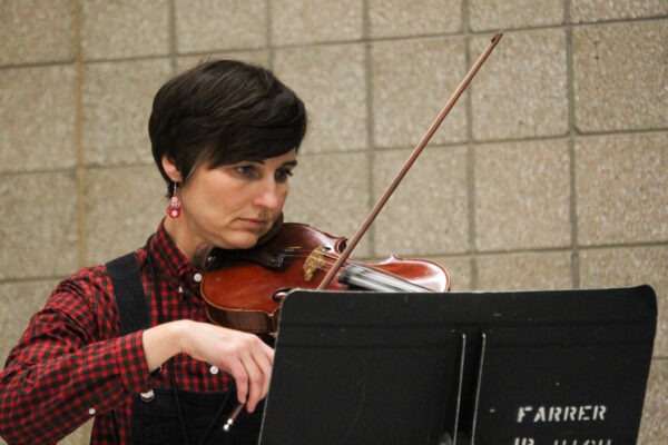 Teacher playing the violin durning the concert.