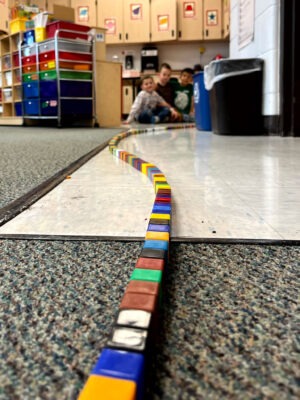 Children completing a string of 100 cubes.