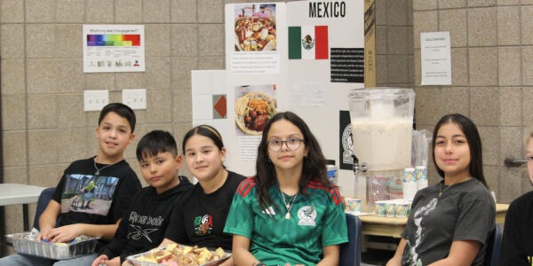 Children sitting with Mexico display.