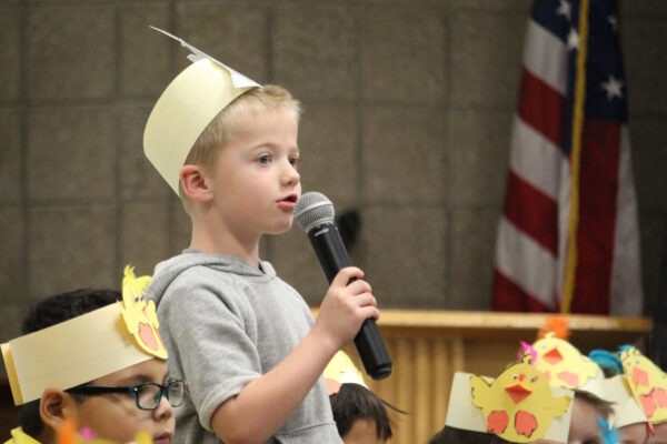 Kindergarten boy dressed as the wolf speaking in microphone.
