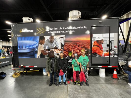 students stand in front of sign about technology